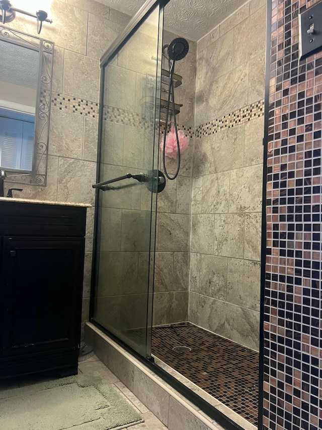 bathroom featuring a textured ceiling, a stall shower, and vanity