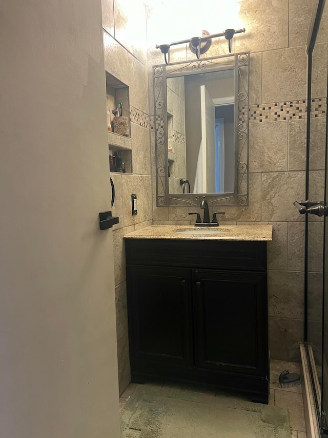 bathroom featuring vanity and tile walls