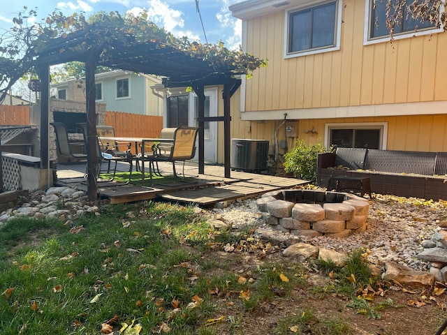 back of property with a wooden deck, central air condition unit, fence, and a fire pit