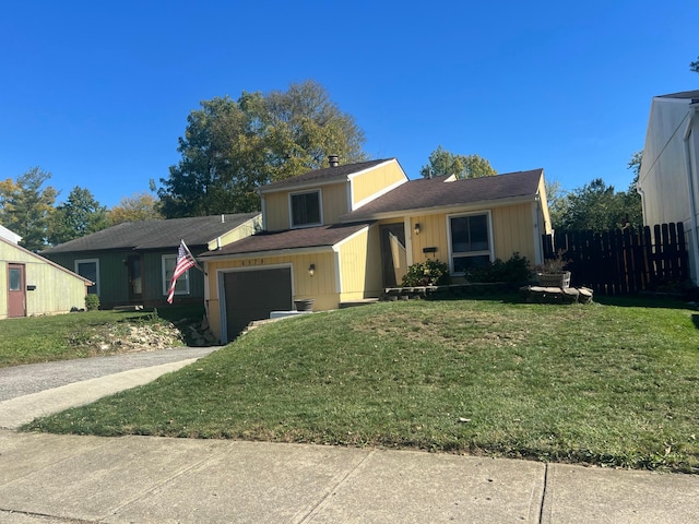 view of front of property featuring a garage, driveway, a front yard, and fence