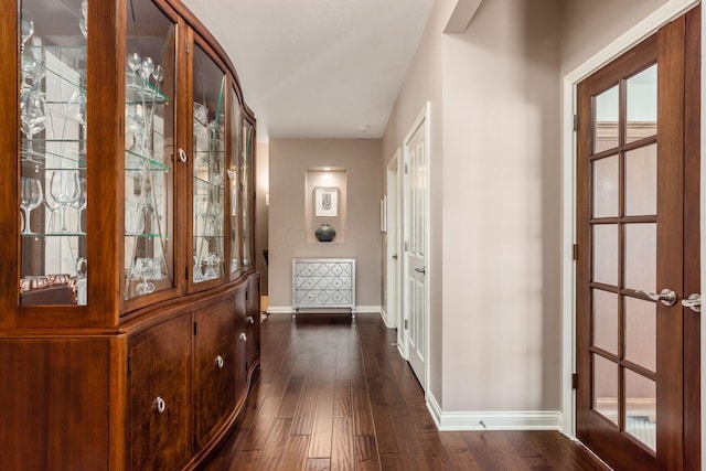 hallway with baseboards and dark wood-style flooring