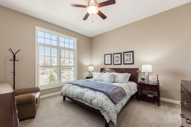 bedroom with ceiling fan, baseboards, and light carpet