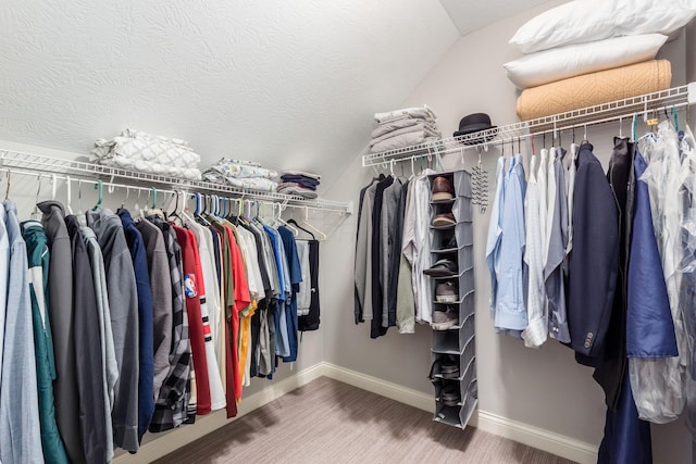 walk in closet with wood finished floors and vaulted ceiling