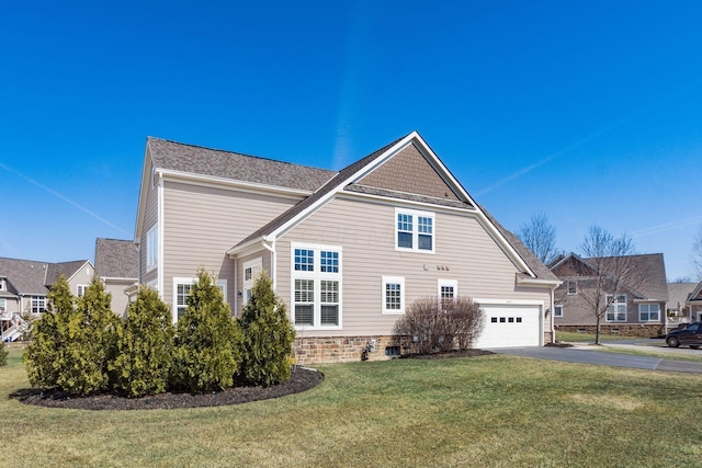 view of home's exterior featuring aphalt driveway, a lawn, and a garage