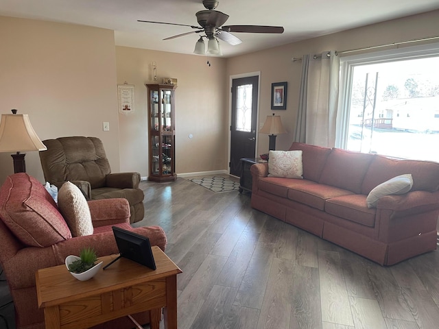 living room with a wealth of natural light, baseboards, ceiling fan, and wood finished floors