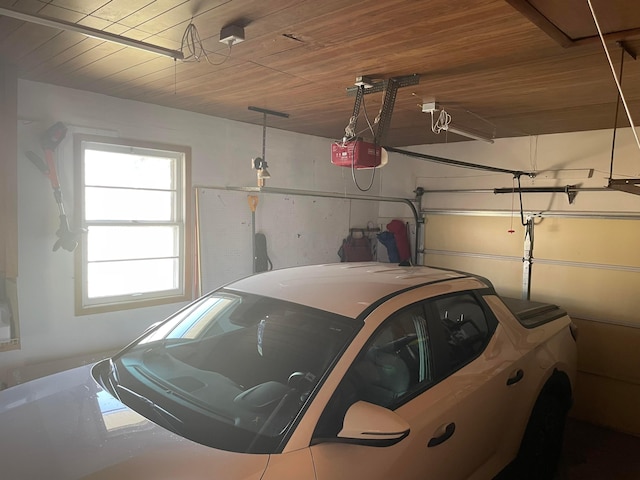 garage featuring wood ceiling and a garage door opener