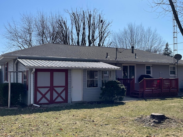 back of house with a wooden deck, a yard, and a shingled roof