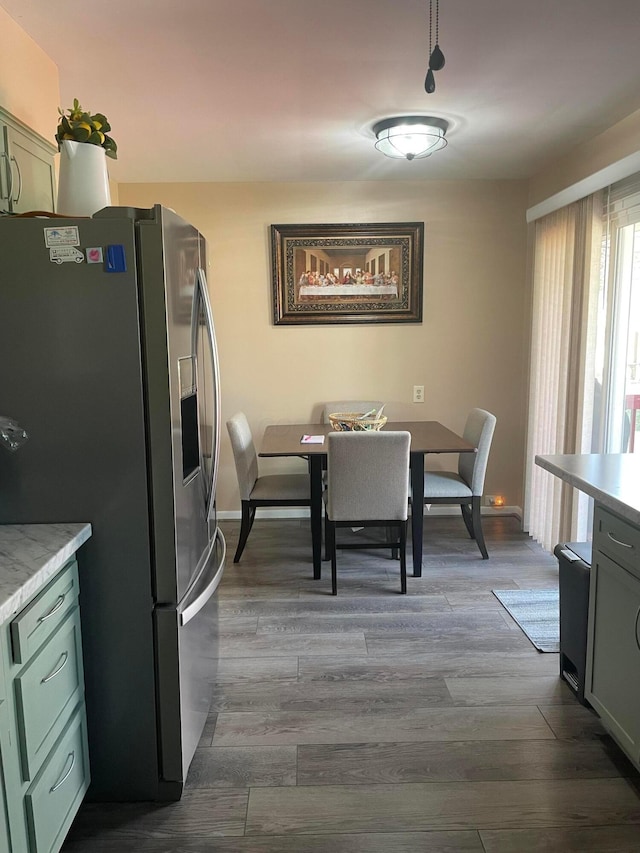 kitchen featuring stainless steel fridge, dark wood-type flooring, and light countertops