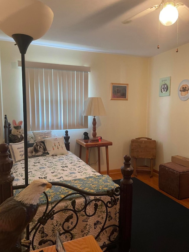 bedroom featuring a ceiling fan, wood finished floors, and baseboards