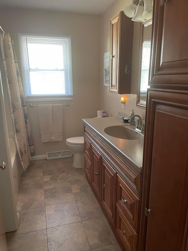 full bathroom featuring toilet, plenty of natural light, vanity, and visible vents