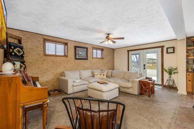 living room featuring french doors, baseboards, and a textured ceiling