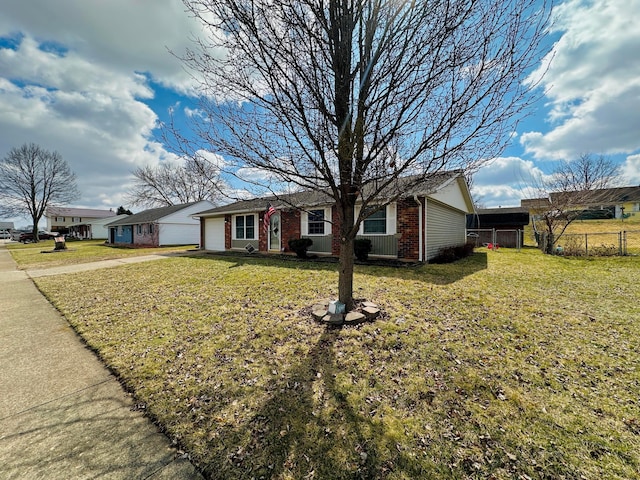 ranch-style house featuring brick siding, driveway, a front lawn, and fence