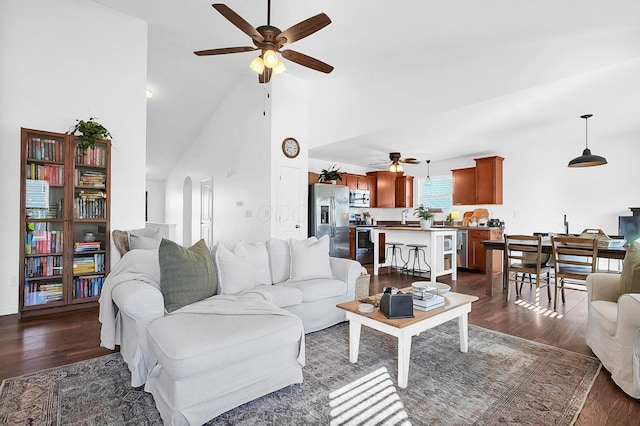 living area with arched walkways, high vaulted ceiling, dark wood-type flooring, and a ceiling fan