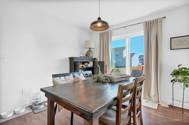 dining space featuring wood finished floors and baseboards