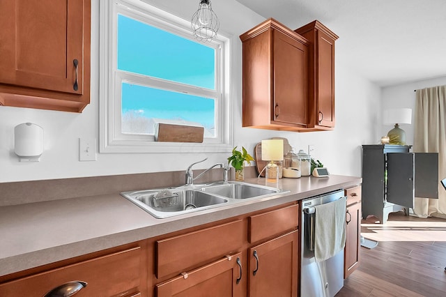 kitchen featuring wood finished floors, a sink, light countertops, dishwasher, and brown cabinets