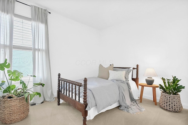 bedroom with multiple windows, carpet flooring, and baseboards