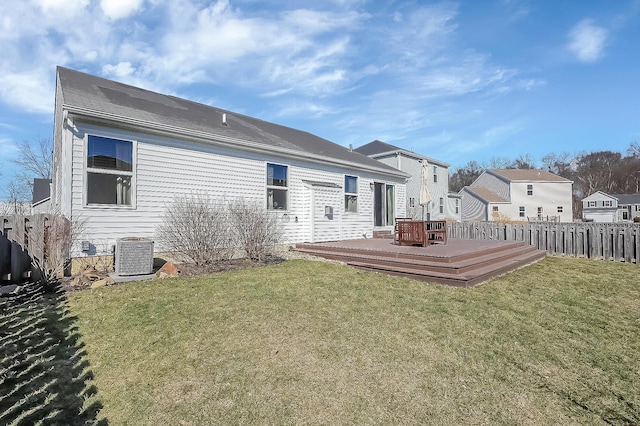 back of property featuring central AC unit, a lawn, a deck, and fence