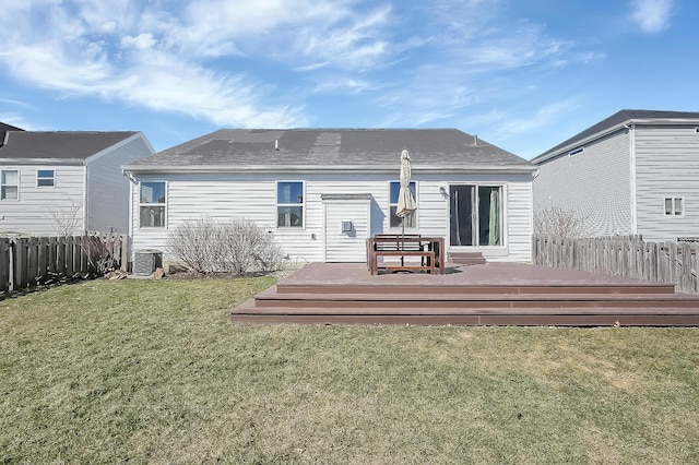 back of property with cooling unit, a lawn, fence, and a wooden deck