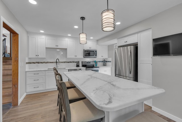 kitchen with a sink, white cabinetry, and stainless steel appliances