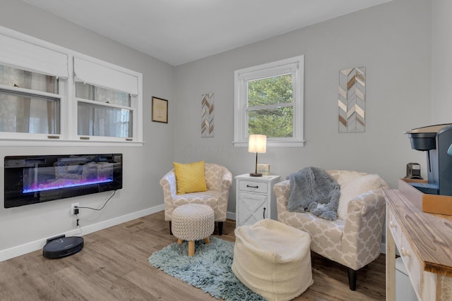 sitting room with visible vents, baseboards, and wood finished floors