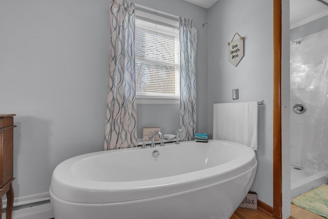 full bath featuring baseboards and a soaking tub