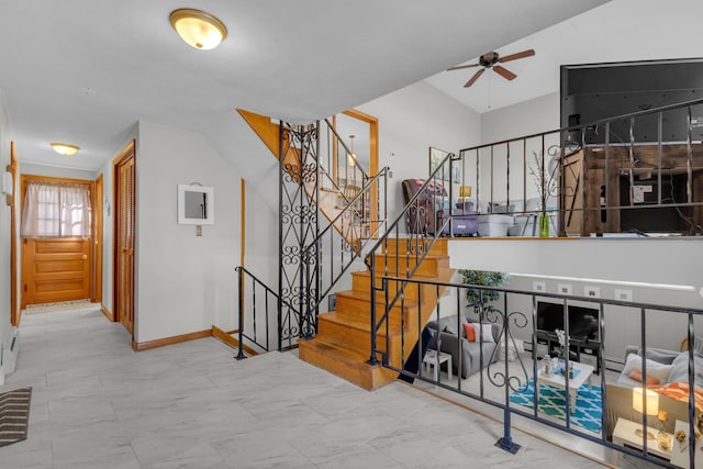 stairway featuring baseboards and ceiling fan