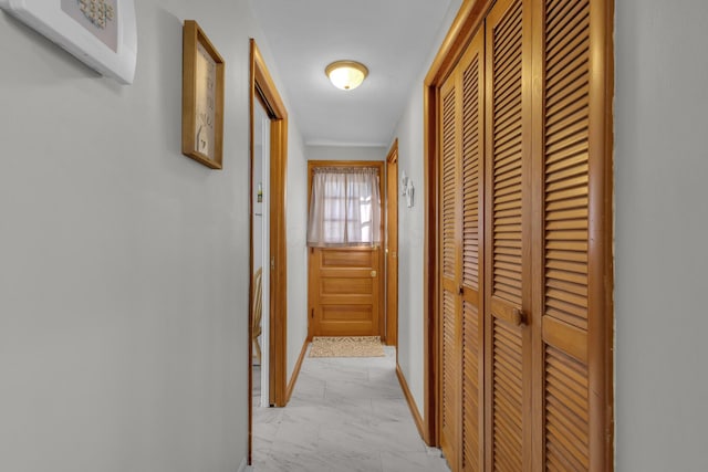 hall with baseboards and marble finish floor