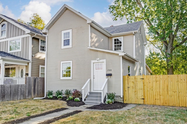 traditional-style home with entry steps and fence