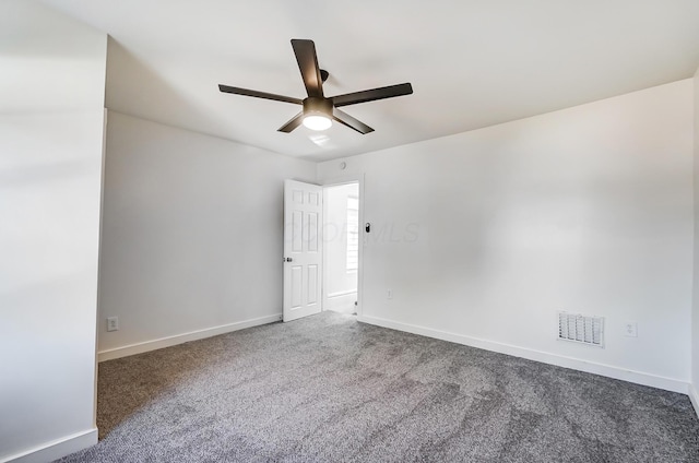 carpeted spare room featuring visible vents, a ceiling fan, and baseboards