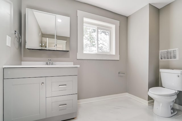 half bathroom featuring visible vents, baseboards, toilet, and vanity