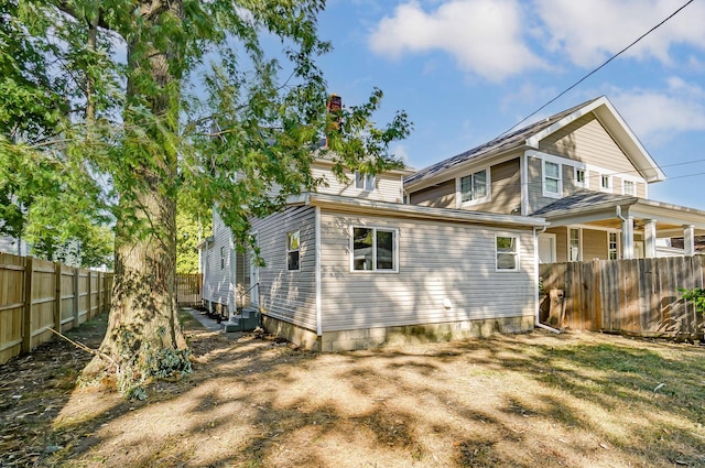 back of property featuring entry steps and fence