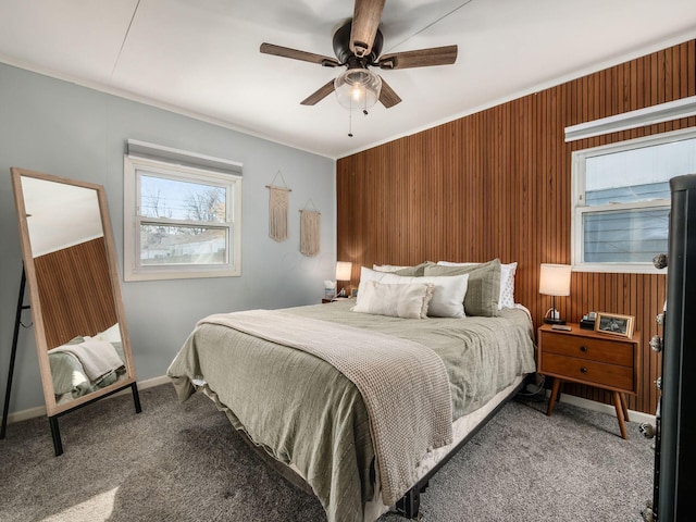 carpeted bedroom featuring wood walls, a ceiling fan, and ornamental molding