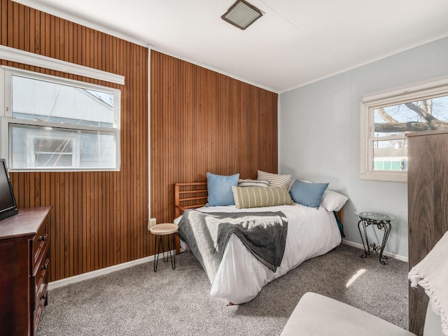 carpeted bedroom featuring wooden walls and baseboards