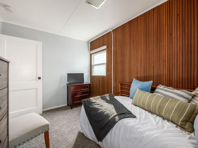 bedroom with carpet flooring and wooden walls