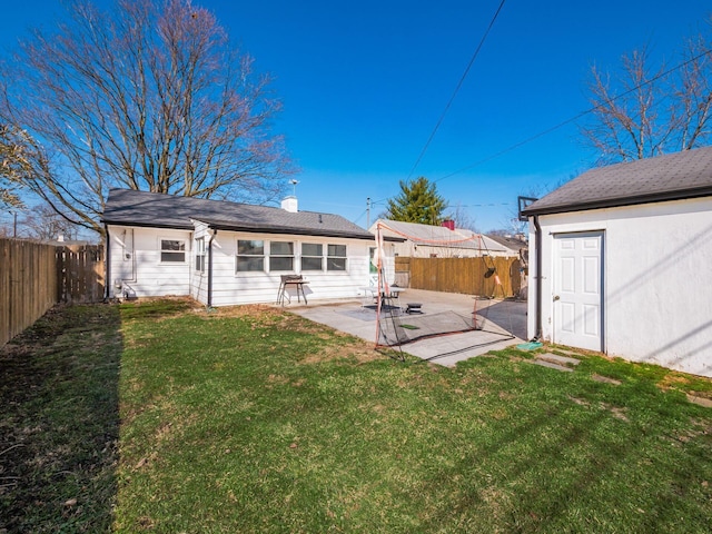 rear view of property with an outbuilding, a lawn, a patio, and a fenced backyard