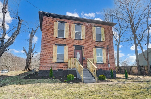 view of front of house featuring a front lawn, fence, and brick siding