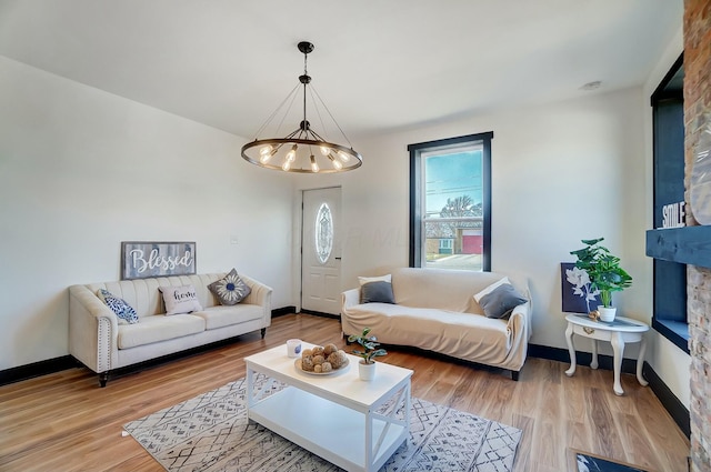 living room with an inviting chandelier, wood finished floors, and baseboards