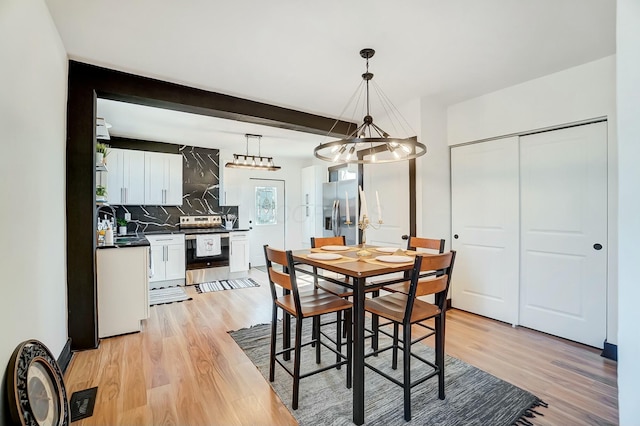 dining area featuring beamed ceiling, visible vents, and light wood finished floors