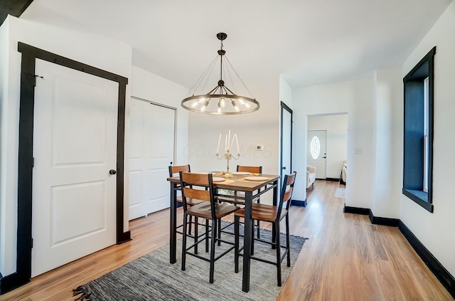 dining room featuring light wood-type flooring and baseboards