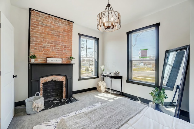 bedroom with baseboards, carpet floors, an inviting chandelier, and a fireplace with flush hearth