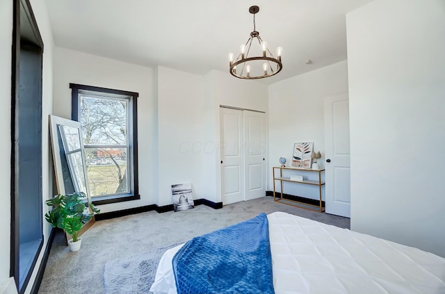 carpeted bedroom with baseboards, a closet, and a chandelier