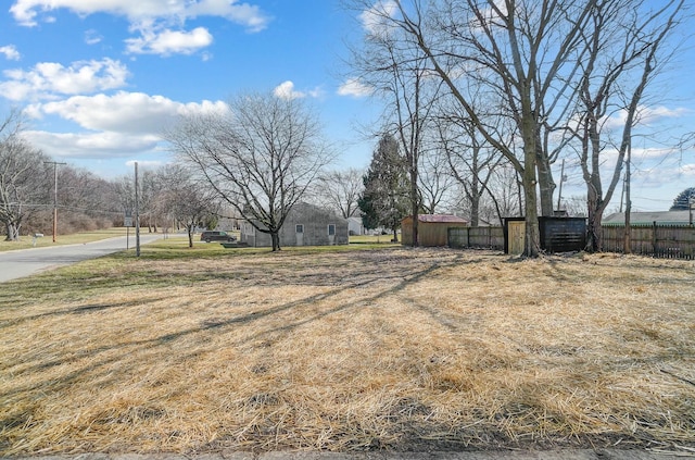 view of yard with an outbuilding, a storage shed, and fence