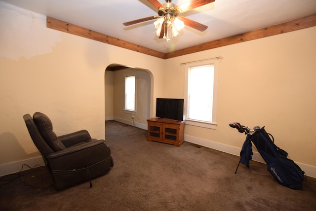 living area with visible vents, baseboards, arched walkways, ceiling fan, and carpet flooring