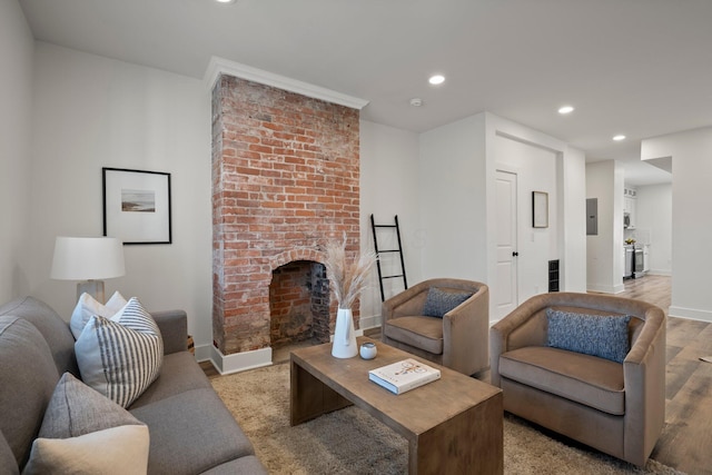 living room featuring recessed lighting, a fireplace, baseboards, and light wood-style floors