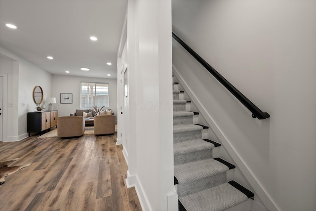 stairs with recessed lighting, baseboards, and wood finished floors