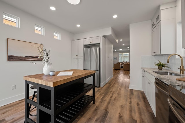 kitchen with a sink, decorative backsplash, appliances with stainless steel finishes, and white cabinets