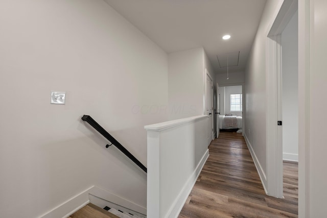 hallway featuring wood finished floors, baseboards, attic access, recessed lighting, and an upstairs landing