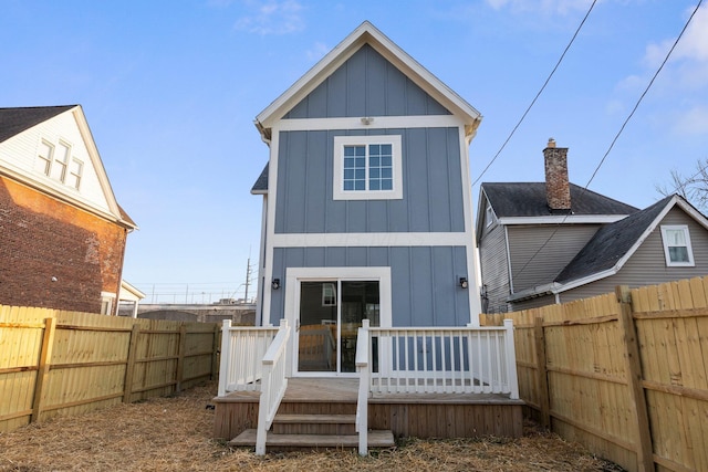 rear view of property with a fenced backyard, board and batten siding, and a deck