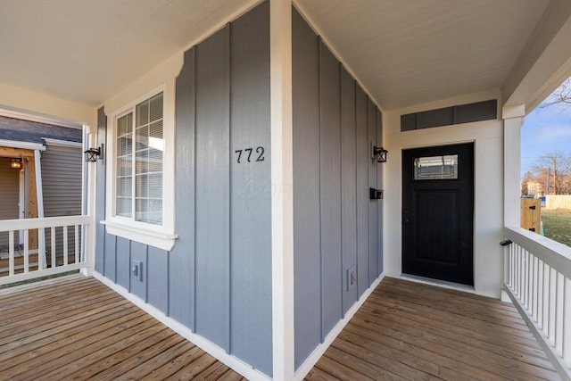 view of exterior entry with a porch and board and batten siding