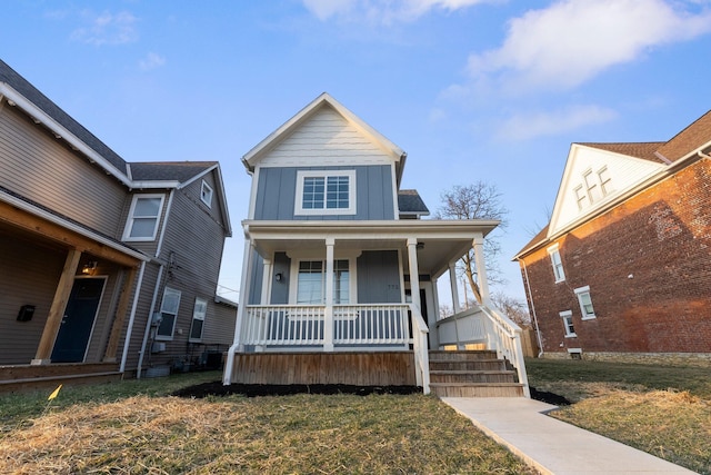 view of front of property with a porch, board and batten siding, and a front yard